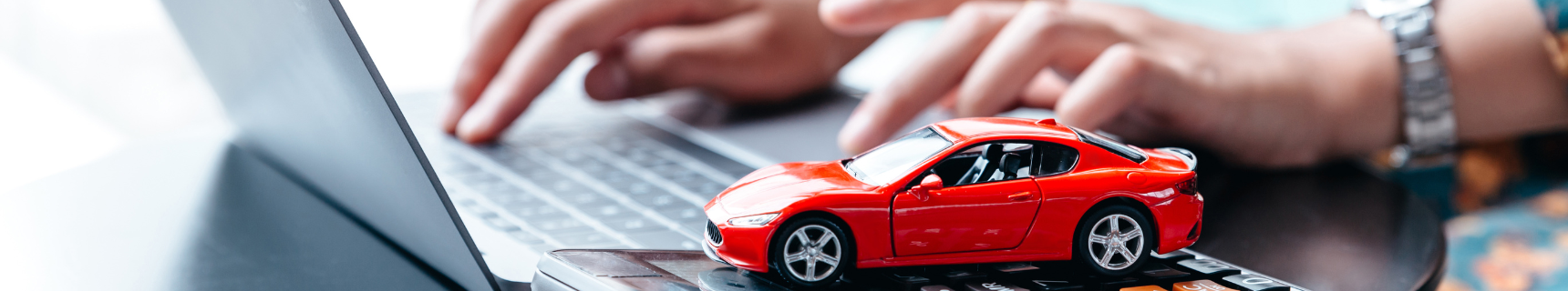 red toy car next to a laptop