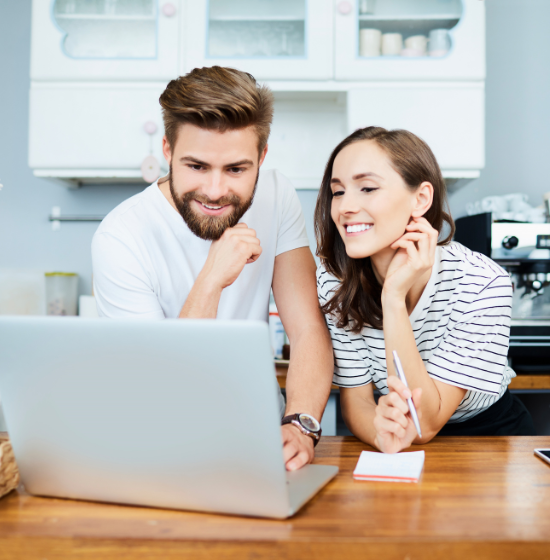 couple looking at laptop in kitchen